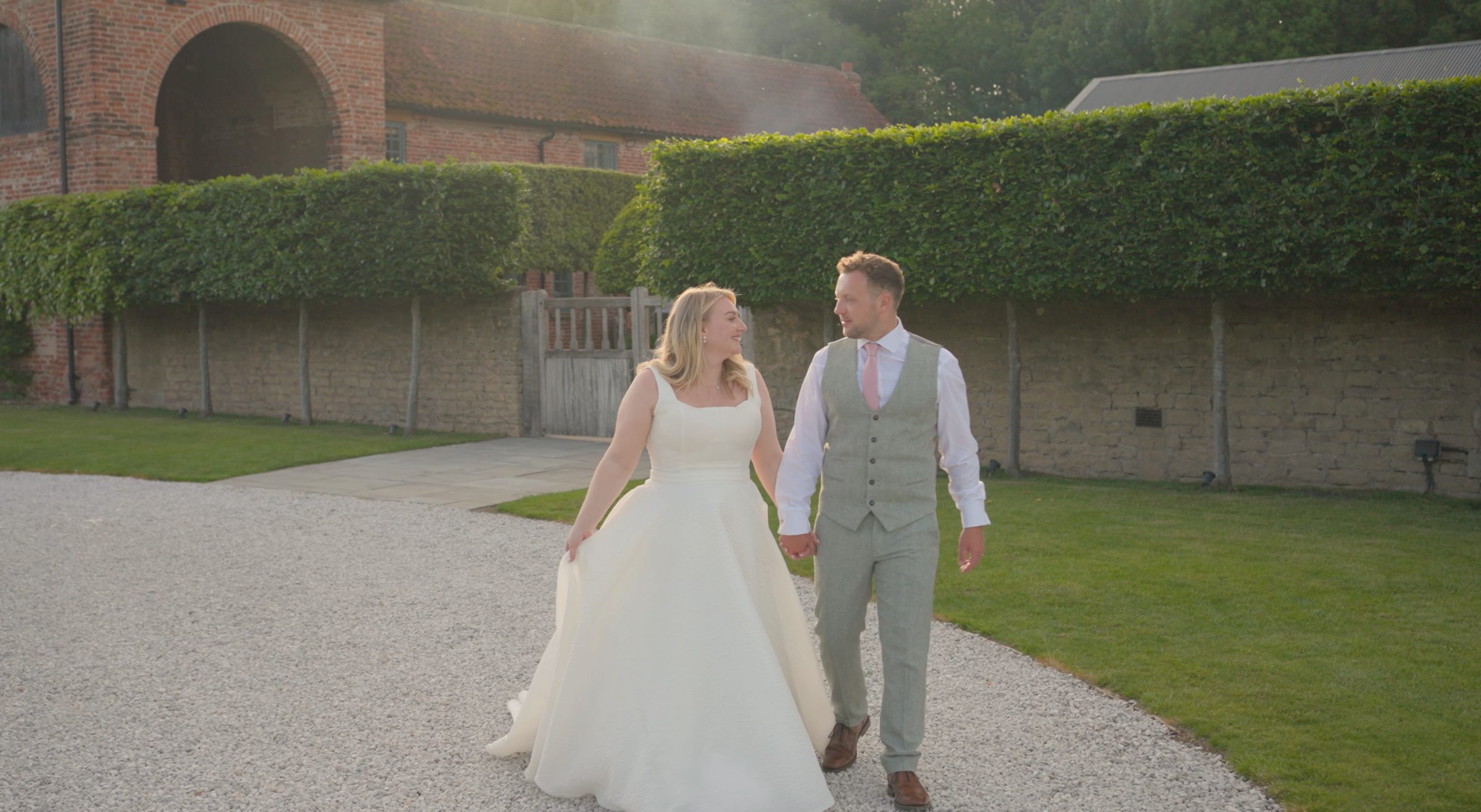 Bride and groom walking hand in hand at golden hour